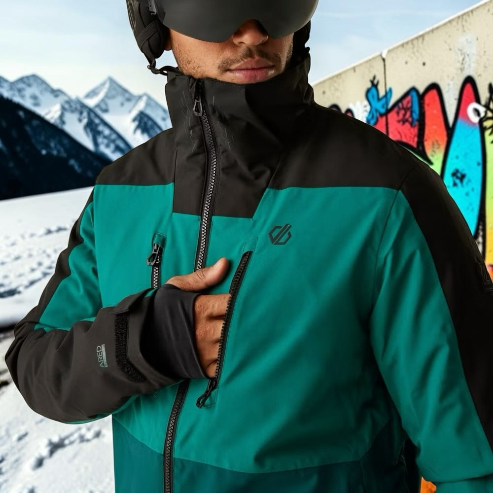 Aurora Fashion men's waterproof teal and black ski jacket with zip pockets and thumb loops worn by a skier