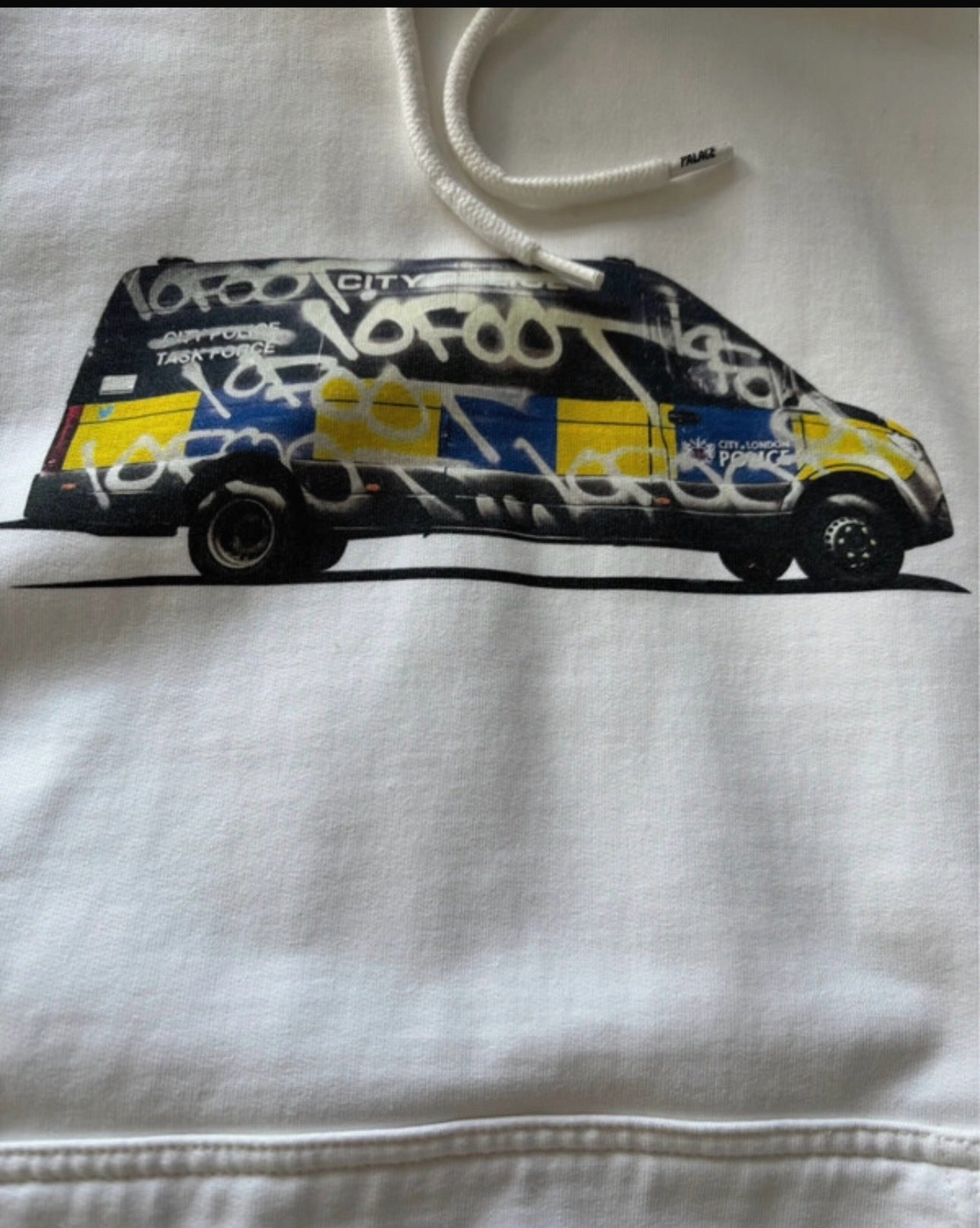 Aurora Fashion white cotton hoodie featuring a graphic print of a graffiti-covered City of London police van
