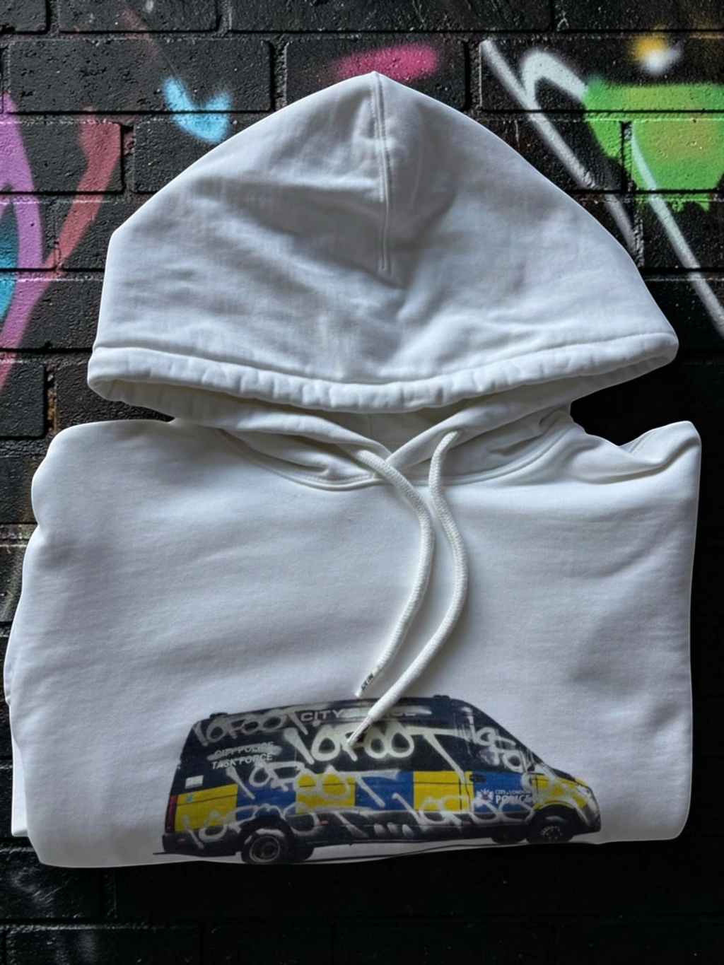 Aurora Fashion white cotton pullover hoodie featuring a graphic print of a graffiti-covered police van on the chest