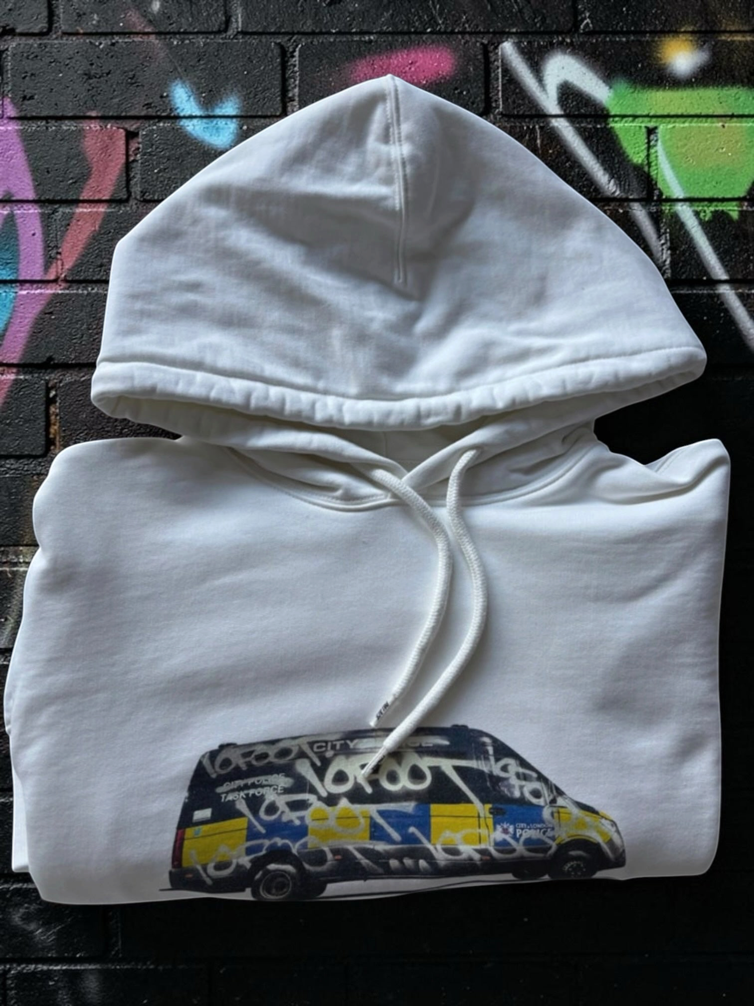 Aurora Fashion white cotton pullover hoodie featuring a graphic print of a graffiti-covered police van on the chest